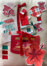 A two-piece kids pyjama set featuring a short-sleeve top and matching shorts in a red, white, and green tartan, with a cream-colored collar, pocket, and drawstring. Made from organic cotton